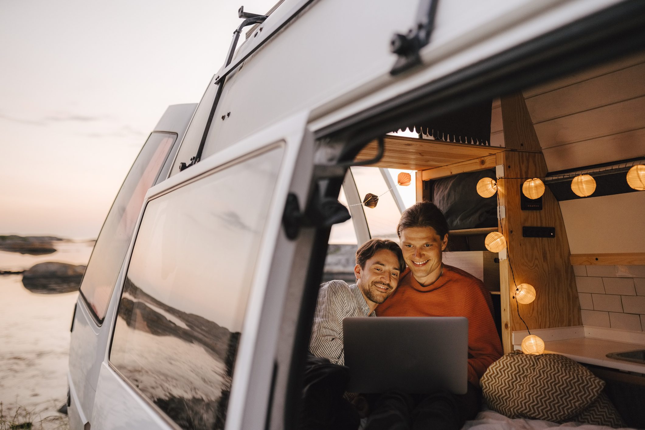 Man Using Laptop Seen Through Doorway of Camping Van